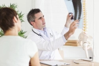 Il medico esegue una diagnosi di malattia degenerativa del disco su una foto